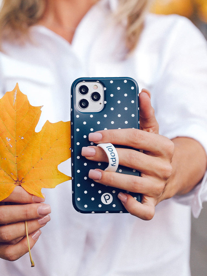 A woman holding a Navy Polka Dot Loopy Case. || feature-media