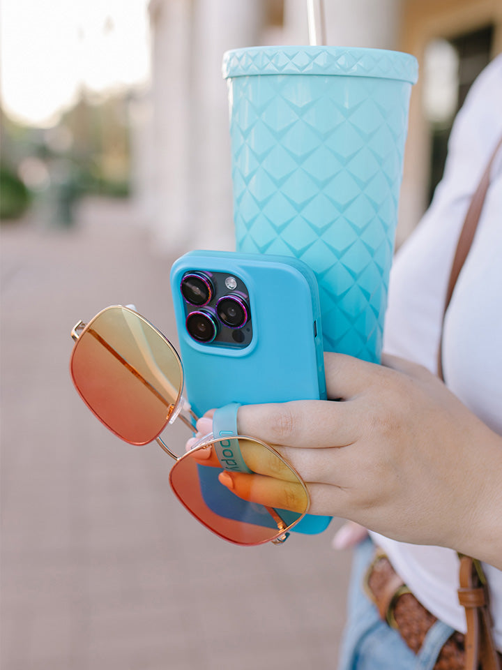 A woman holding a Neon Cyan Loopy Case.|| feature-media