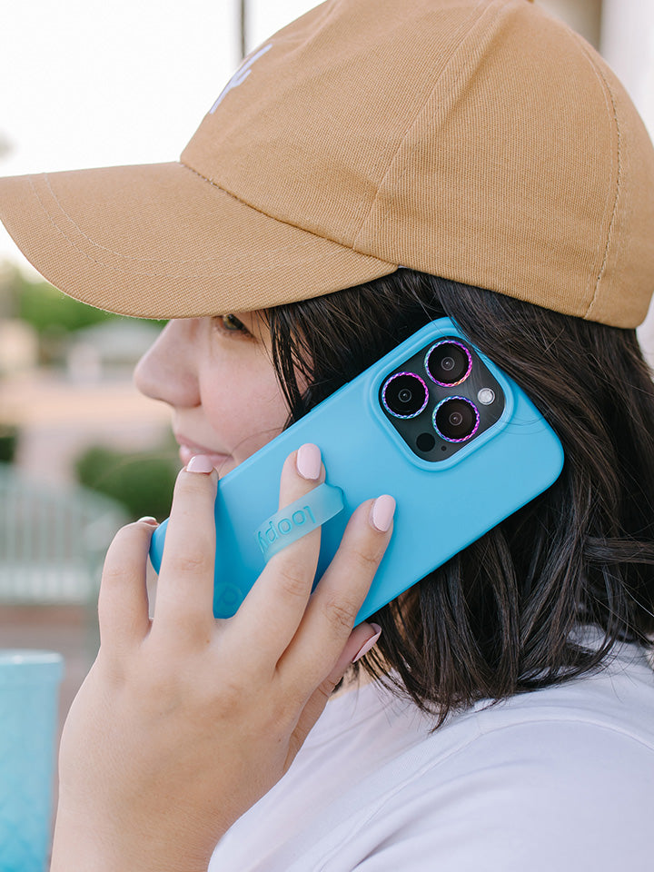 A woman talking on the phone while holding a Neon Cyan Loopy Case.|| feature-media