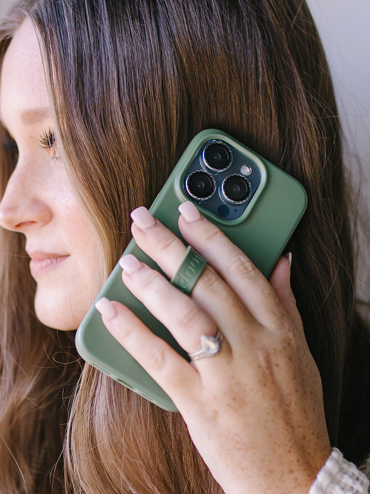 A woman talking on the phone while holding an Olive Loopy Case. || feature-media