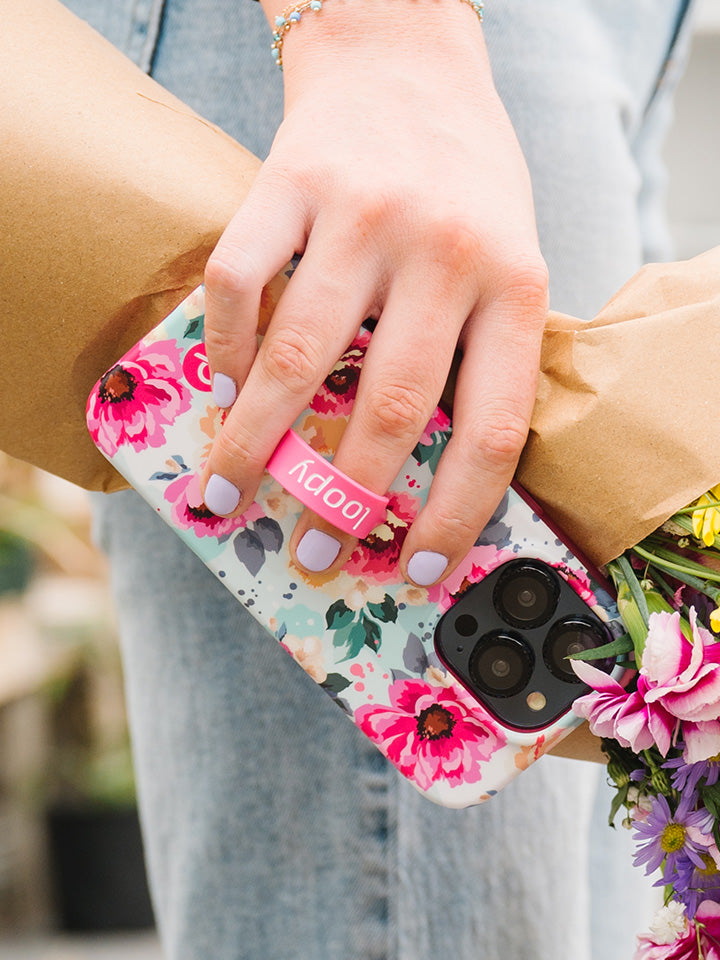 A woman holding a Peonies Loopy Case. || feature-media