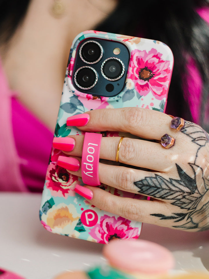 A woman holding a Peonies Loopy Case. || feature-media