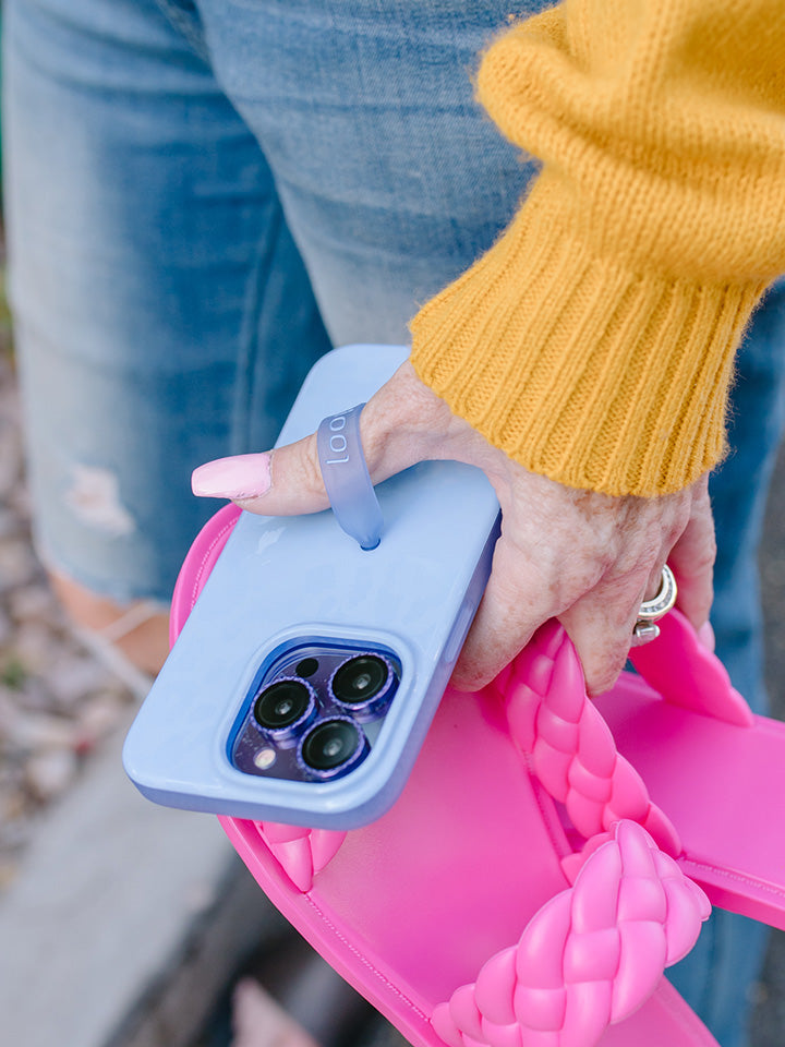 A woman holding a Periwinkle Leopard Loopy Case.|| feature-media