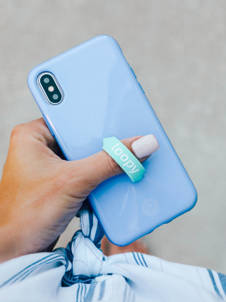 A woman holding a Periwinkle Loopy Case. || feature-media