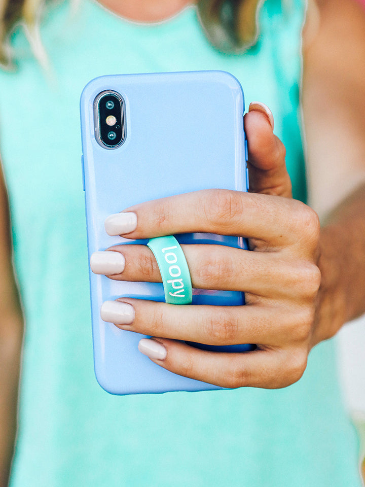 A woman holding a Periwinkle Loopy Case. || feature-media