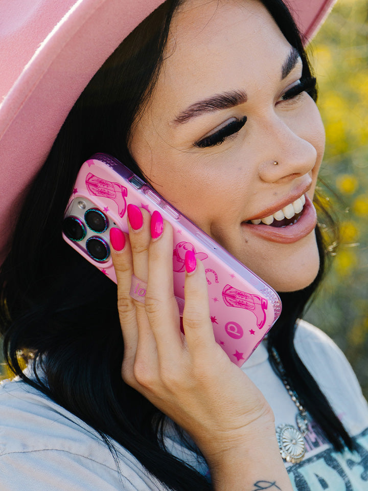 A woman talking on the phone while holding a Pink Boots Loopy Case.|| feature-media