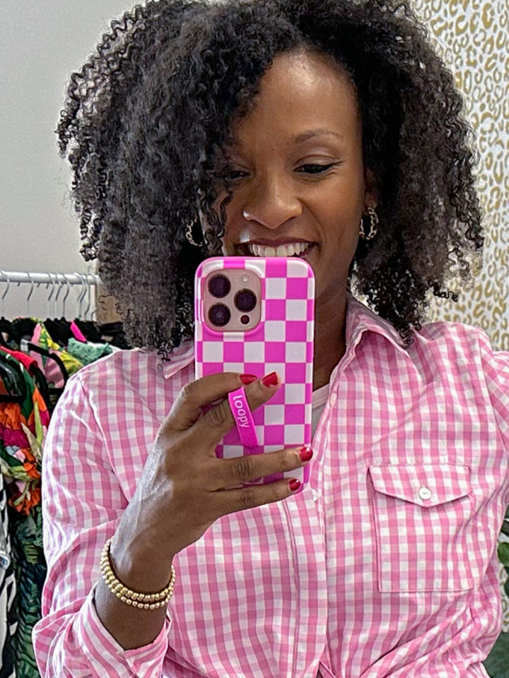 A woman holding a Pink Checkered Loopy Case.|| feature-media