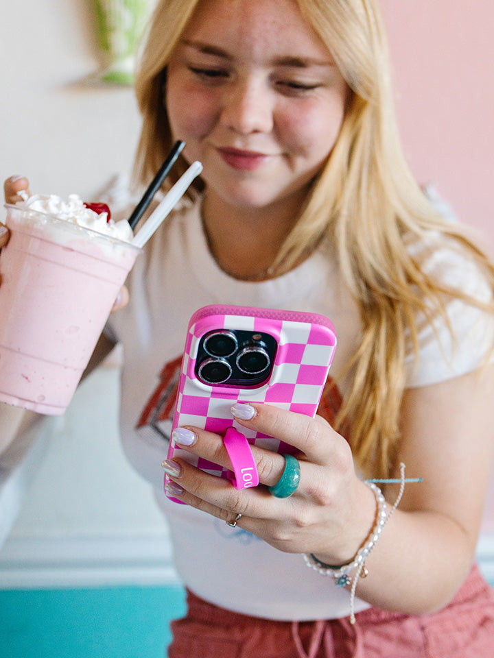 A woman holding a Pink Checkered Loopy Case.|| feature-media