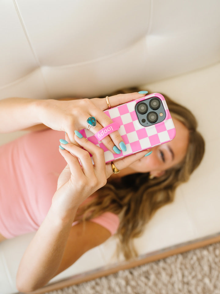 A woman holding a Pink Checkered Loopy Case.