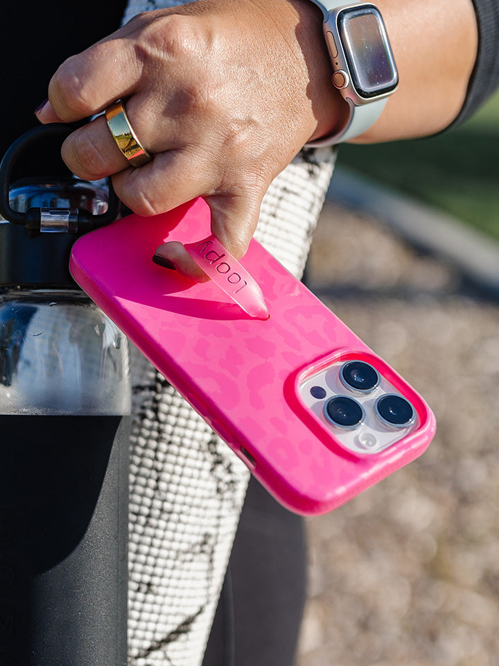 A woman holding a Hot Pink Leopard Loopy Case. || feature-media