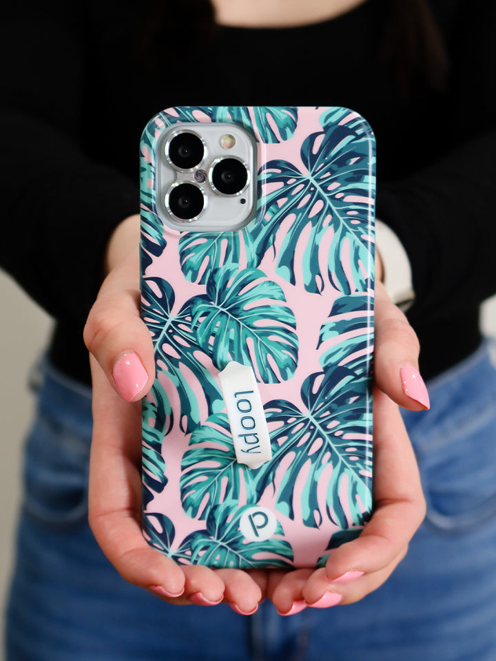 A woman holding a Pink Monstera Loopy Case. || feature-media