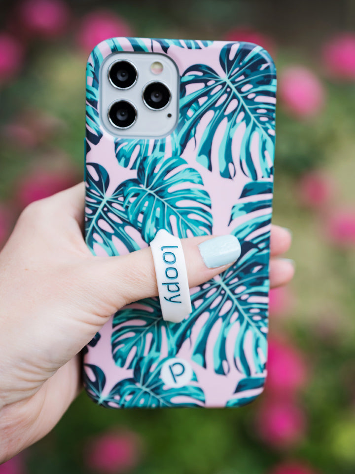 A woman holding a Pink Monstera Loopy Case. || feature-media