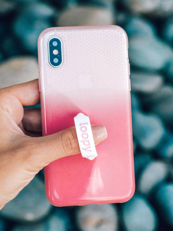 A woman holding a Pink Ombre Loopy Case. || feature-media