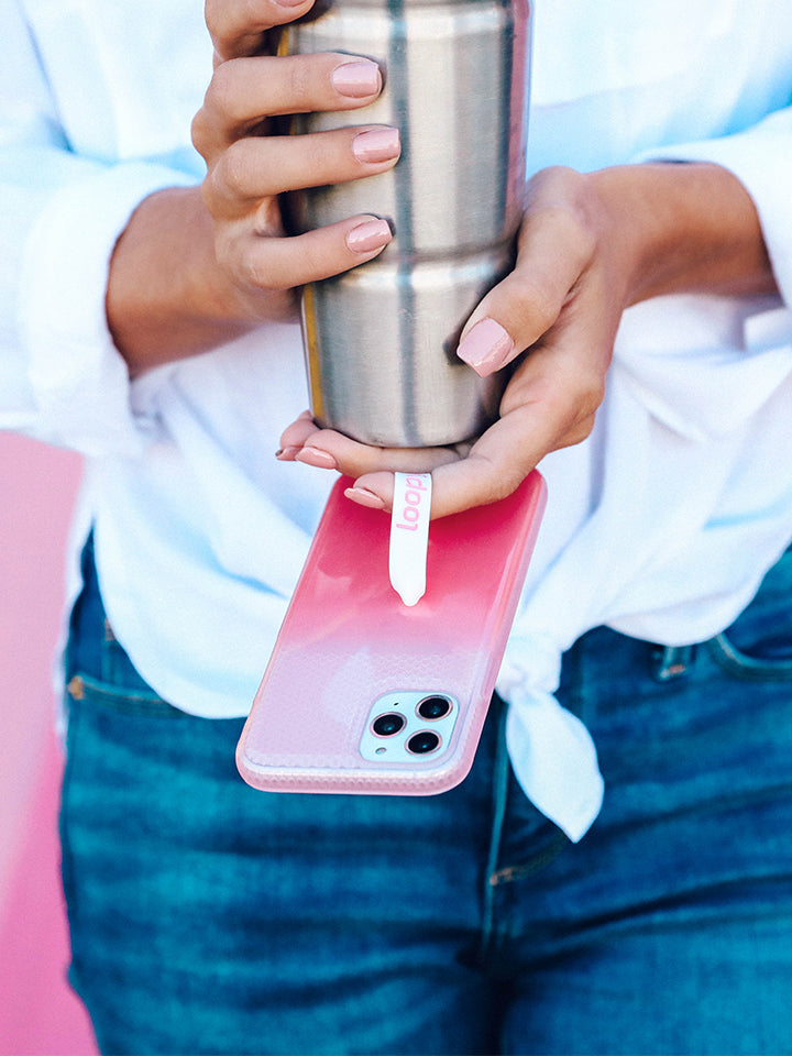 A woman holding a Pink Ombre Loopy Case. || feature-media