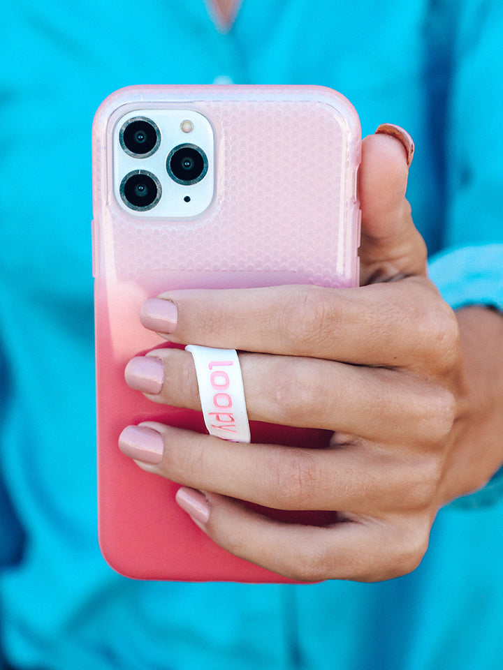 A woman holding a Pink Ombre Loopy Case. || feature-media