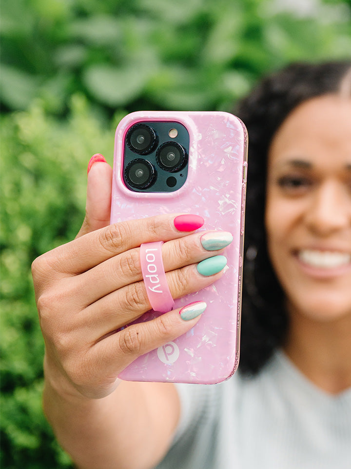 A woman holding a Pink Opal Shell Loopy Case.|| feature-media