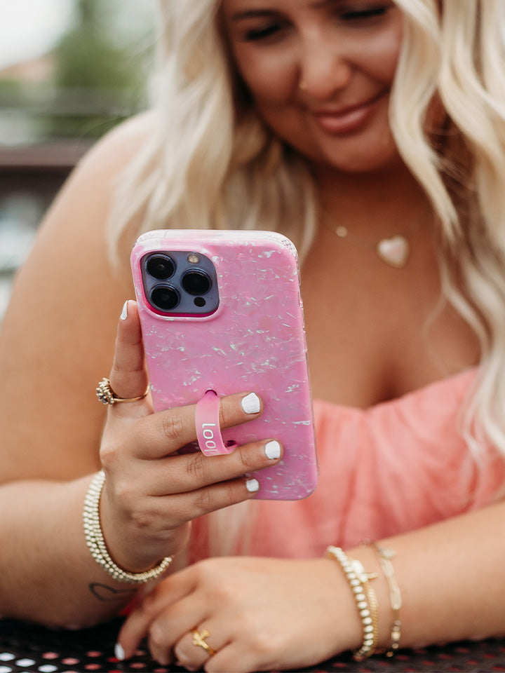 A woman holding a Pink Opal Shell Loopy Case.|| feature-media