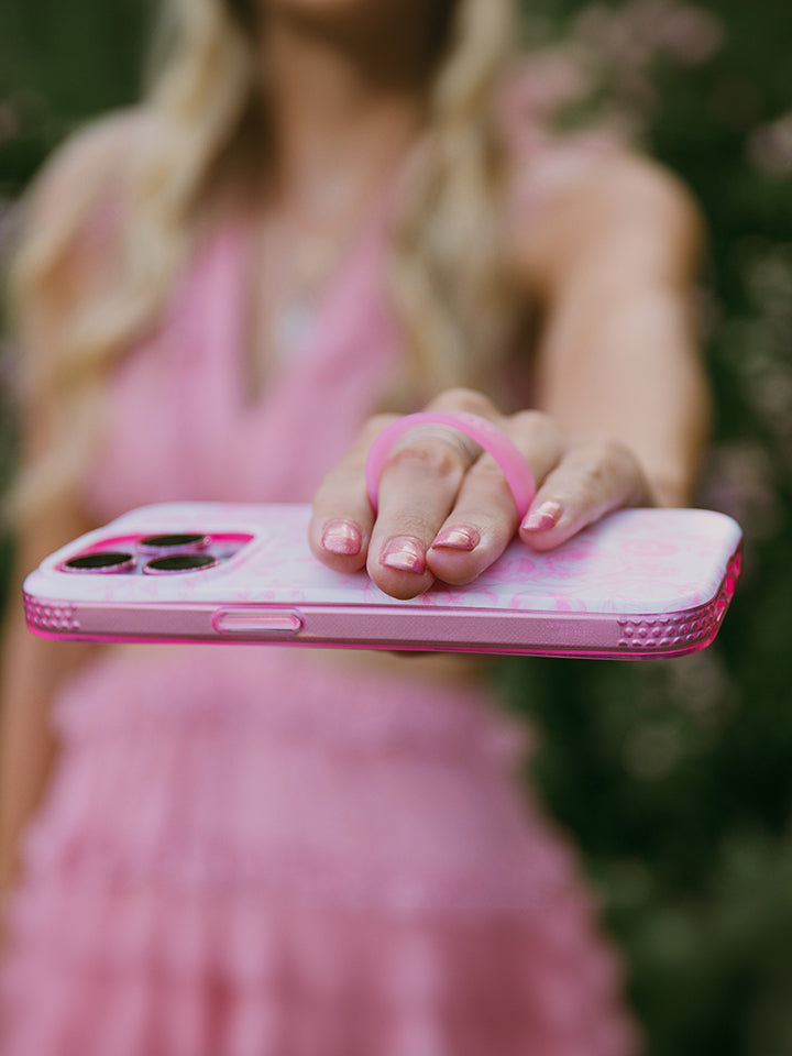 A woman holding a Pink Toile Loopy Case. || feature-media