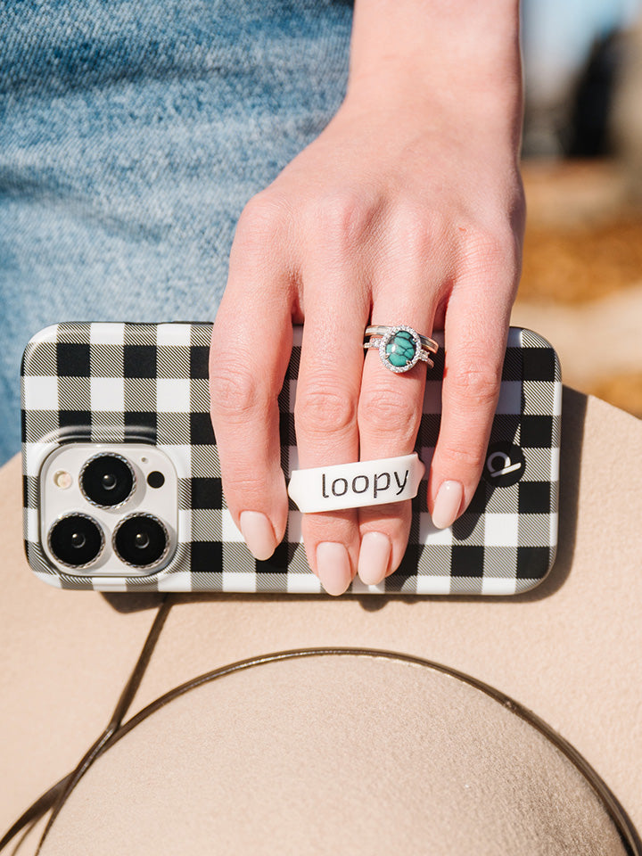 A woman holding a Plaid Loopy Case.|| feature-media