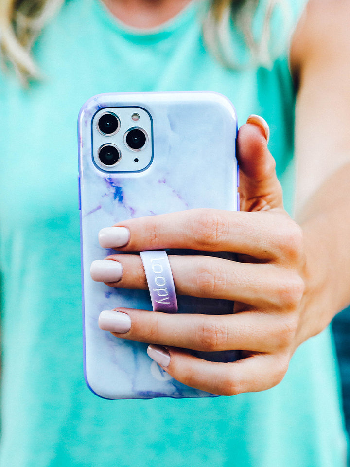 A woman holding a Purple Marble Loopy Case. || feature-media