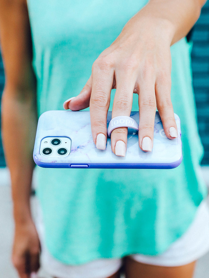 A woman holding a Purple Marble Loopy Case. || feature-media