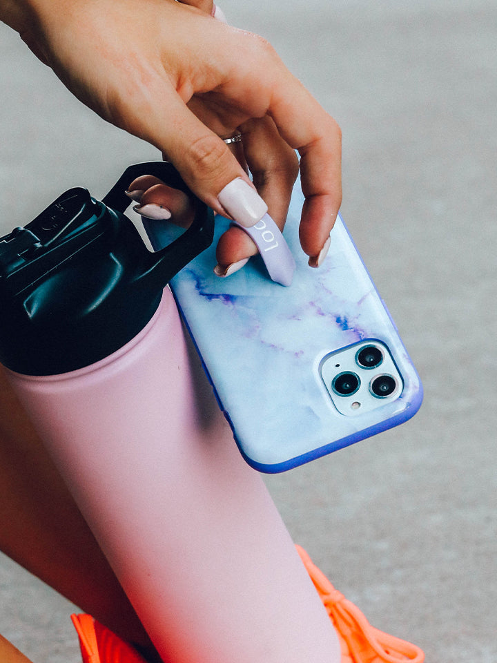 A woman holding a Purple Marble Loopy Case. || feature-media