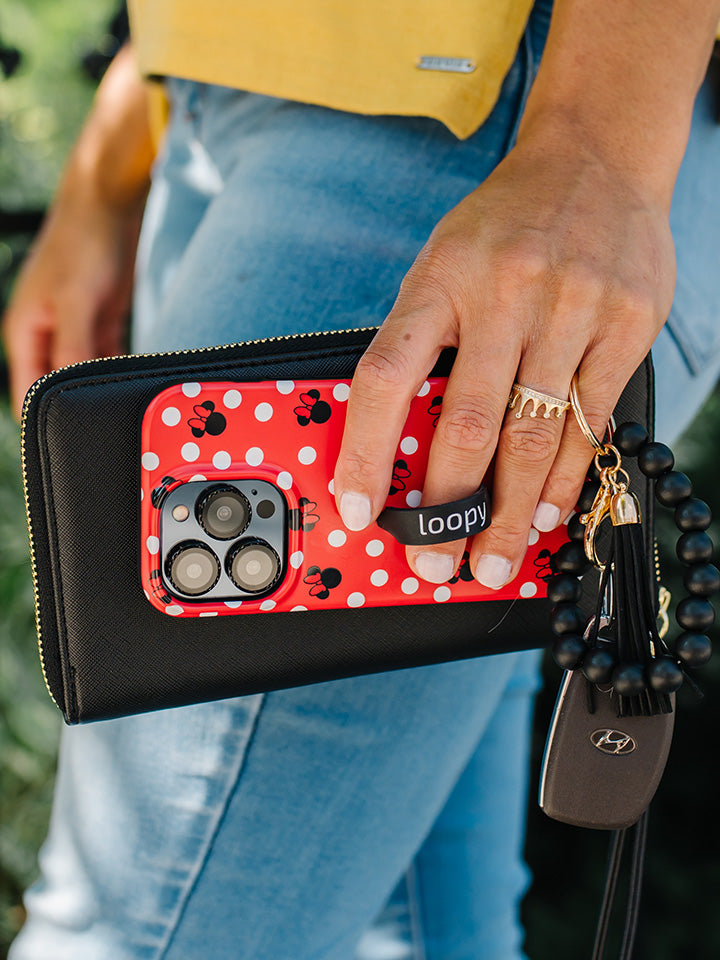 A woman holding a Red Polka Dot Minnies Loopy Case.|| feature-media