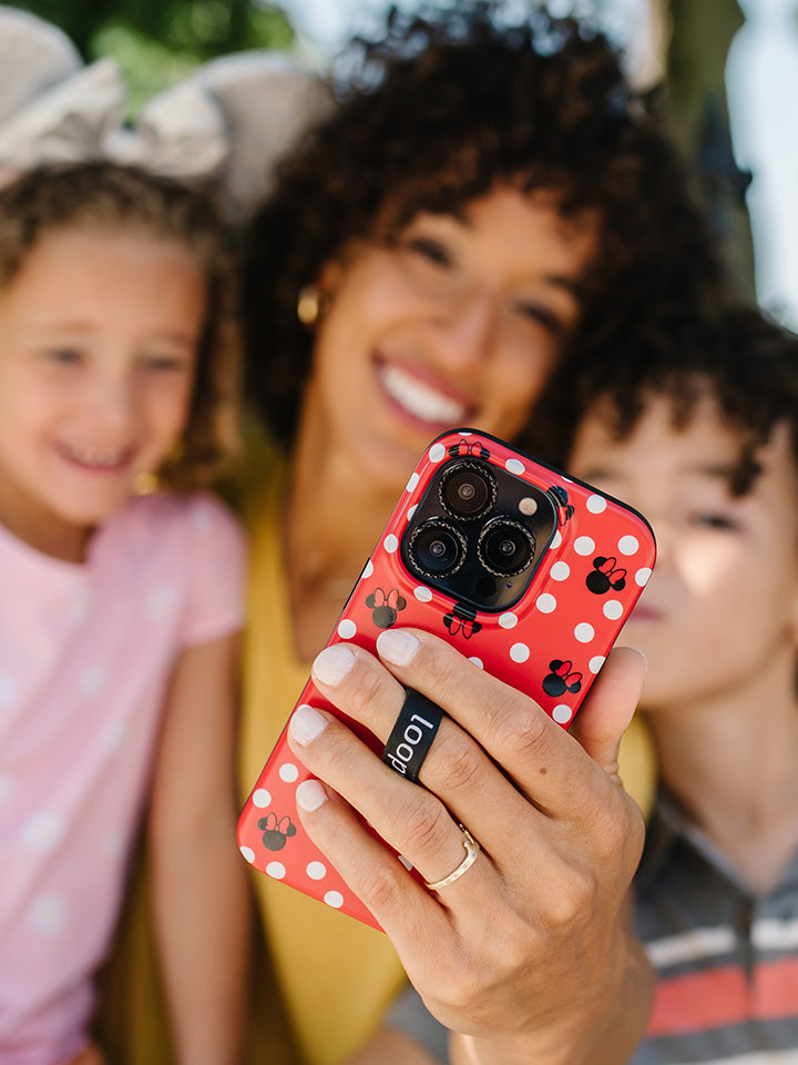 A woman taking a selfie while holding a Red Polka Dot Minnies Loopy Case.|| feature-media