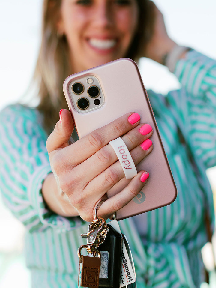 A woman holding a Rose Gold Loopy Case.|| feature-media