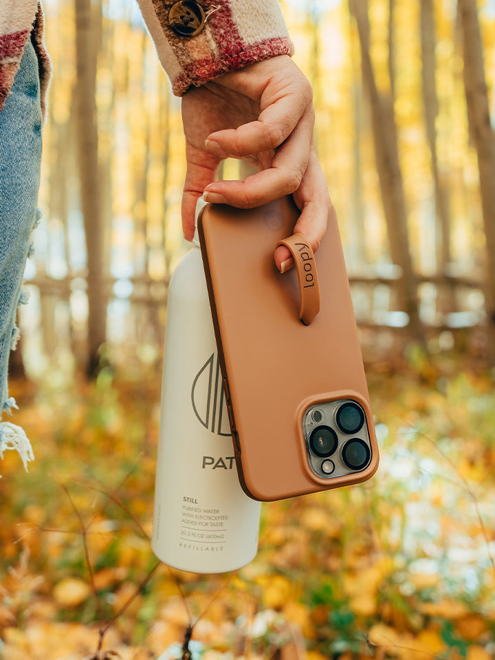 A woman holding a Saddle Brown Loopy Case.|| feature-media