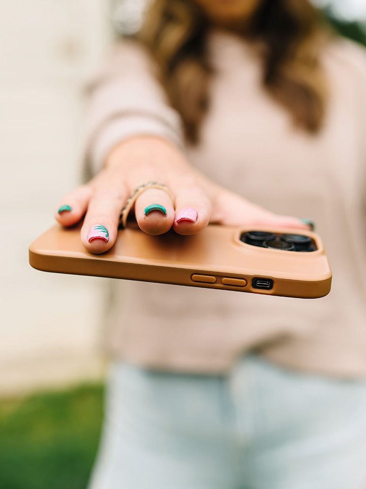 A woman holding a Saddle Brown Loopy Case.|| feature-media