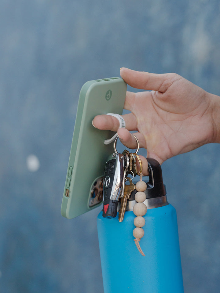 A woman holding a Sage Loopy Case.|| feature-media