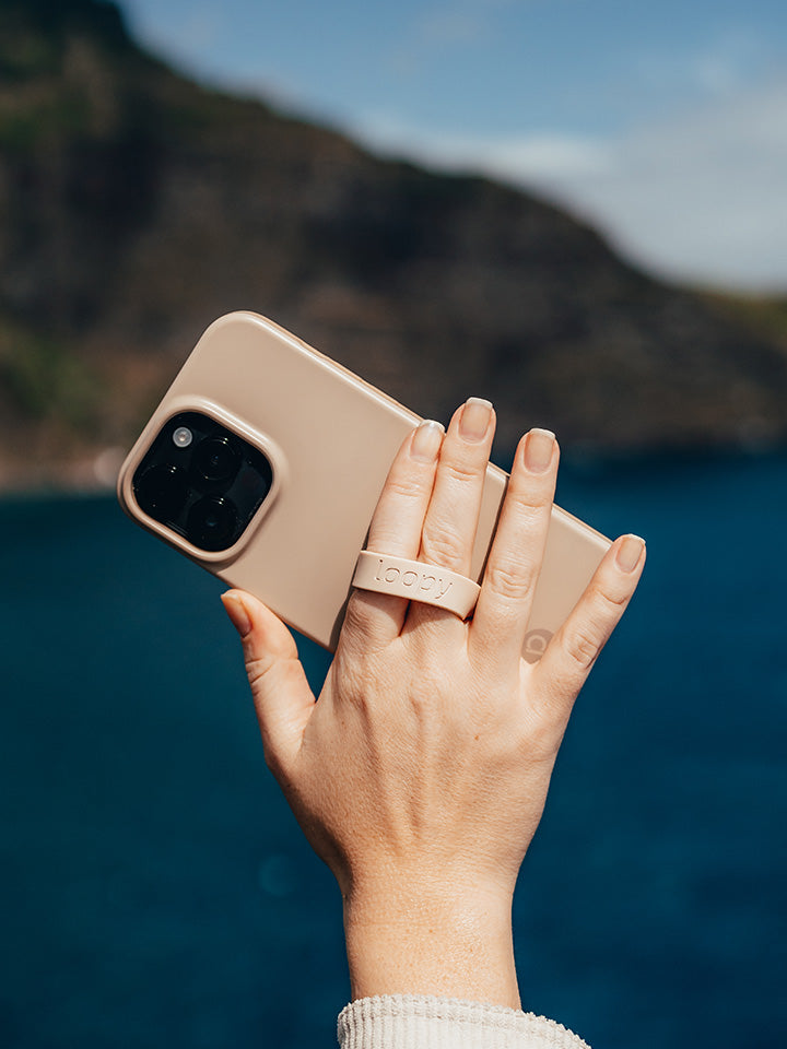 A woman holding a Sandstone Loopy Case. || feature-media