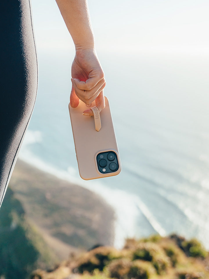 A woman holding a Sandstone Loopy Case. || feature-media