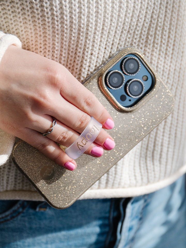 A woman holding a Champagne Sparkle Loopy Case. || feature-media