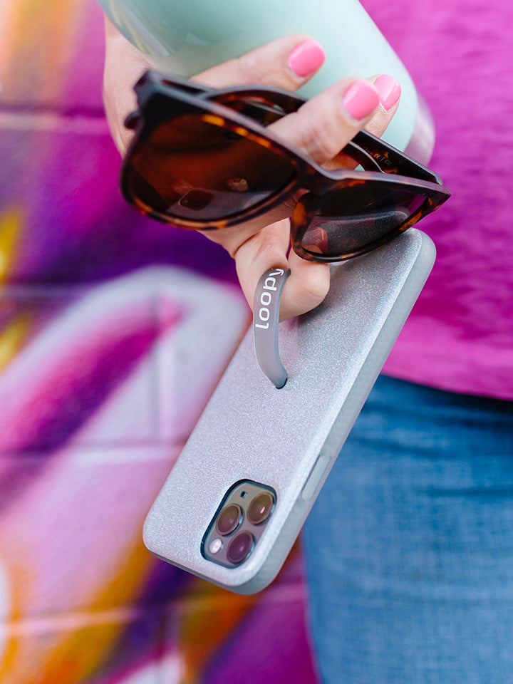 A woman holding a Sparkle Silver Loopy Case.|| feature-media