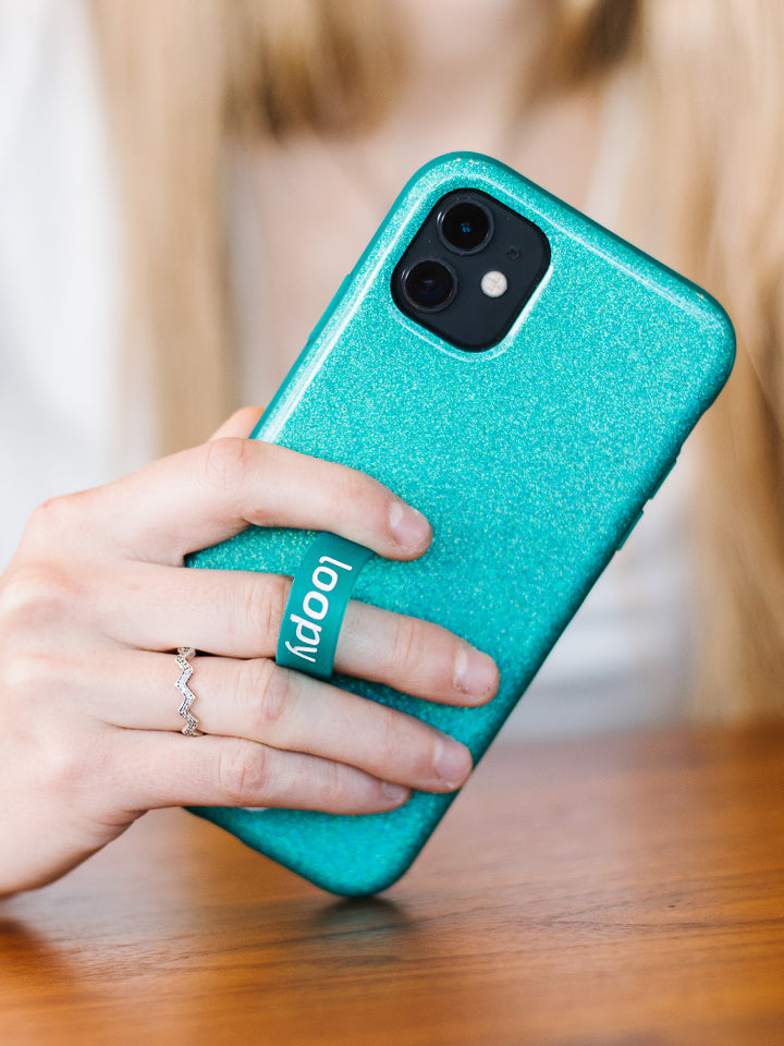 A woman holding a Sparkle Turquoise Loopy Case. || feature-media