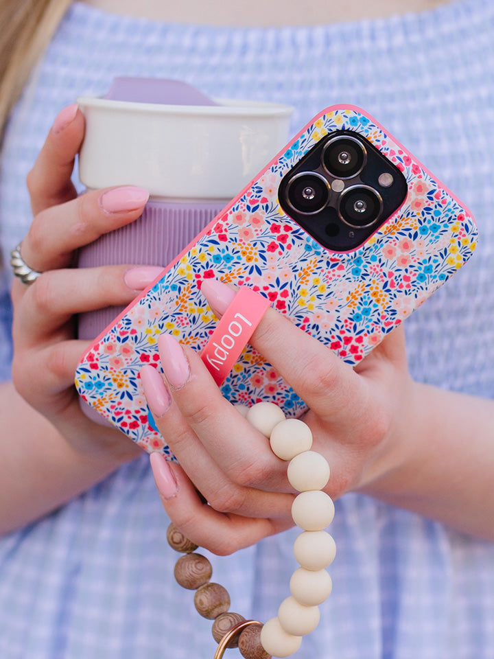 A woman holding a Spring Meadow Loopy Case. || feature-media