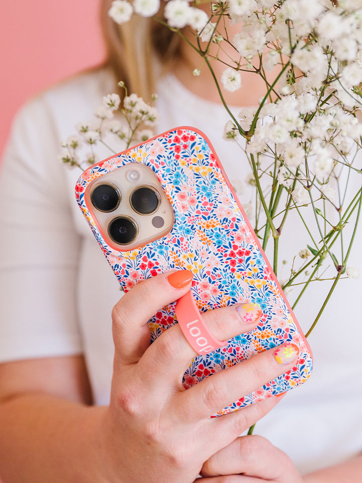 A woman holding a Spring Meadow Loopy Case. || feature-media