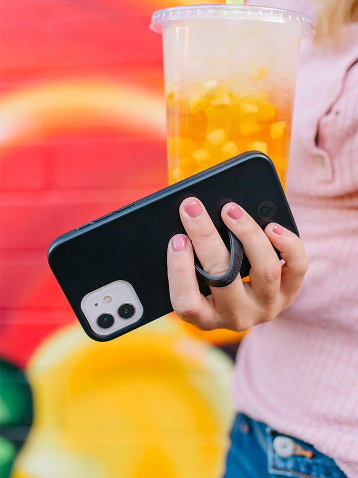 A woman holding a Stealth Black Loopy Case. || feature-media