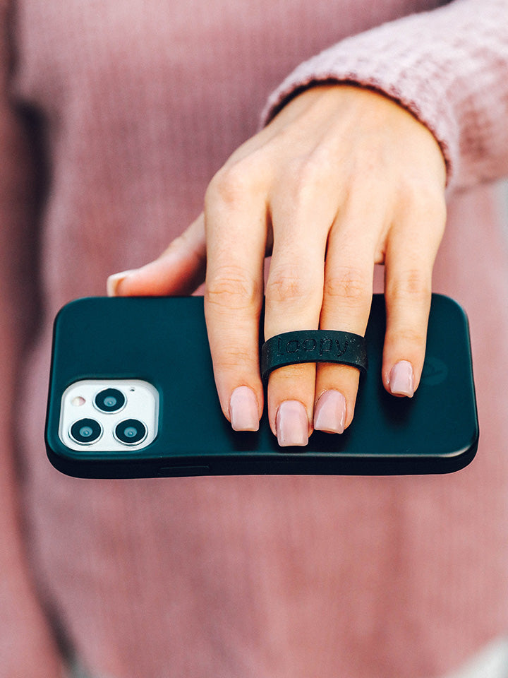 A woman holding a Stealth Black Loopy Case. || feature-media