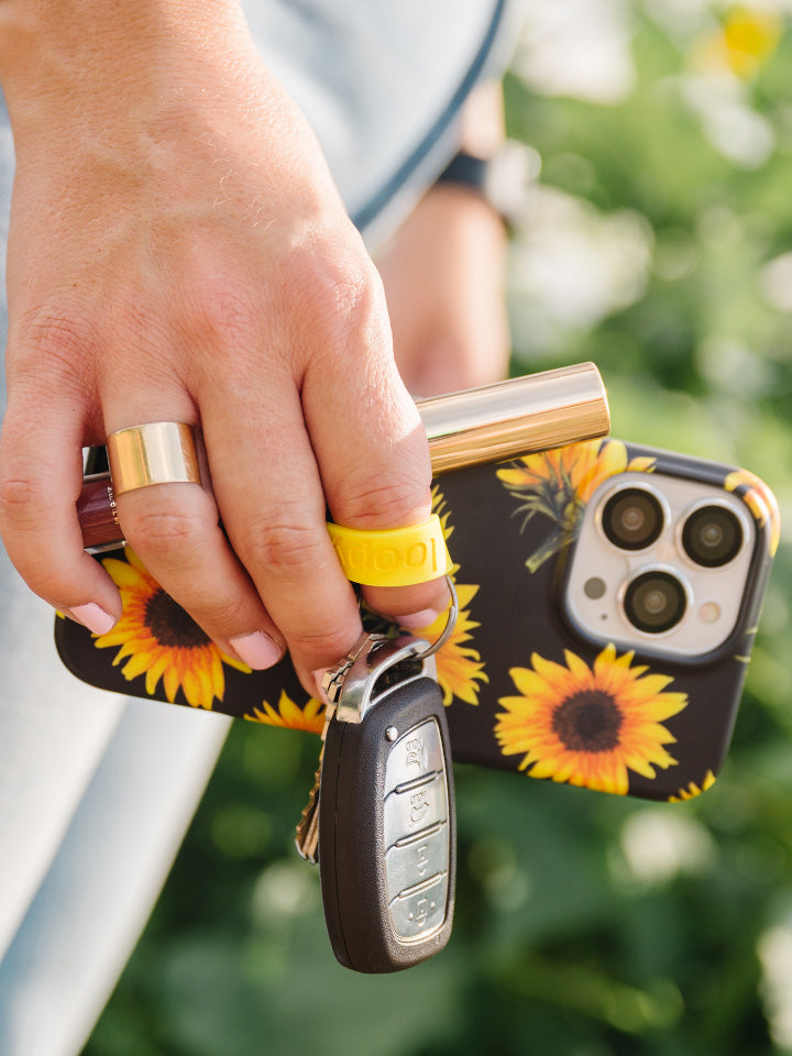  A woman holding a Sunflowers Loopy Case.|| feature-media