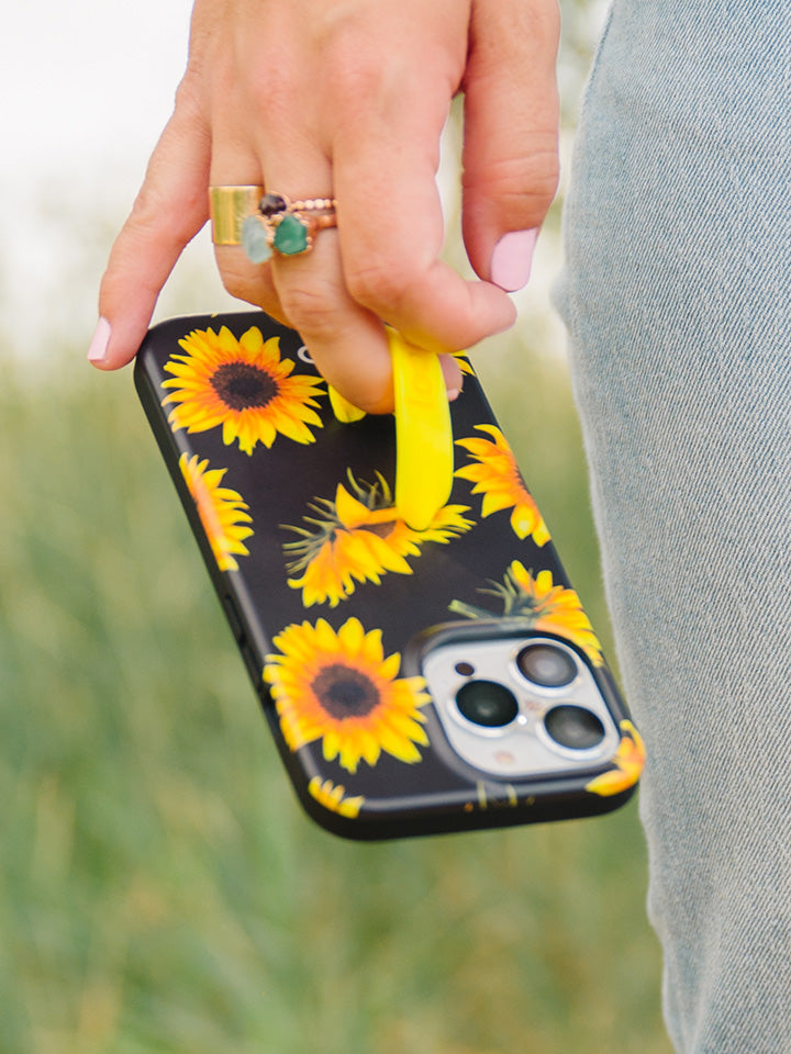 A woman holding a Sunflowers Loopy Case. || feature-media