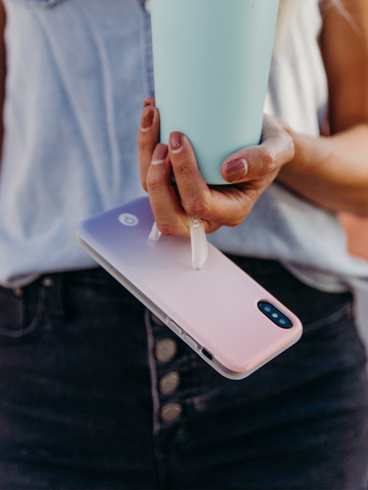 A woman holding a Sunset Loopy Case. || feature-media