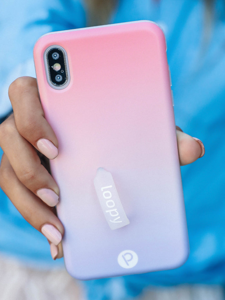 A woman holding a Sunset Loopy Case. || feature-media