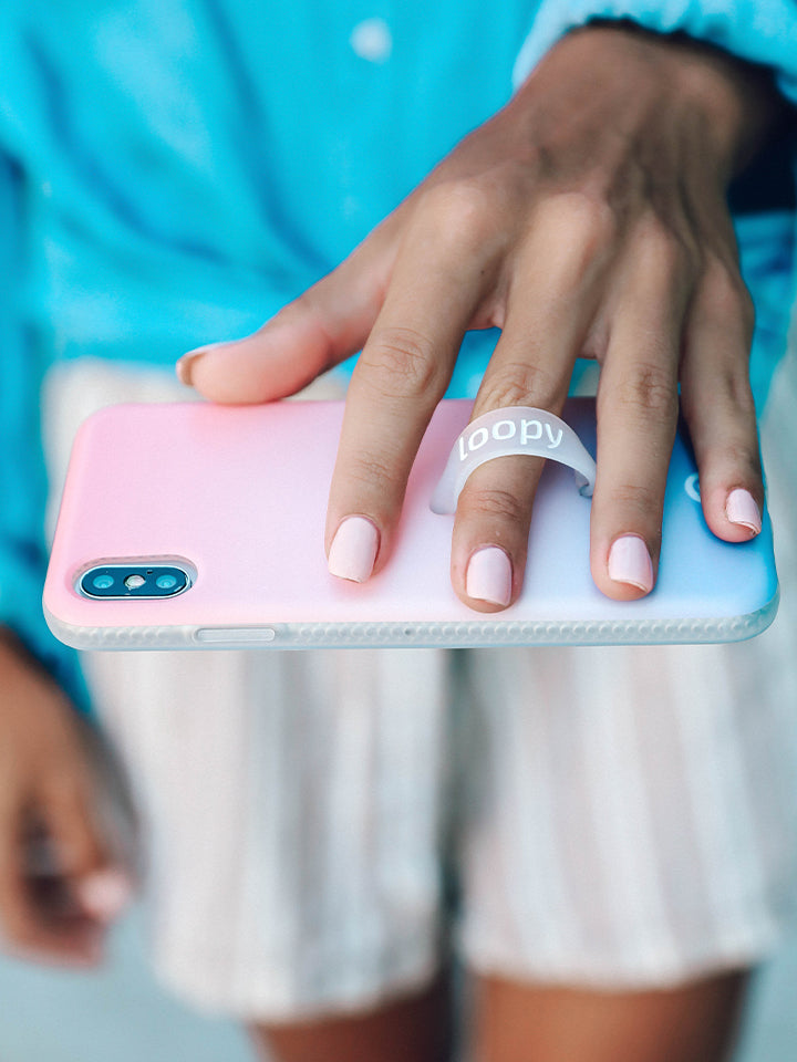 A woman holding a Sunset Loopy Case. || feature-media