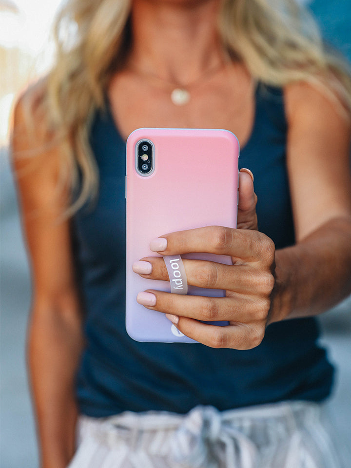 A woman holding a Sunset Loopy Case. || feature-media