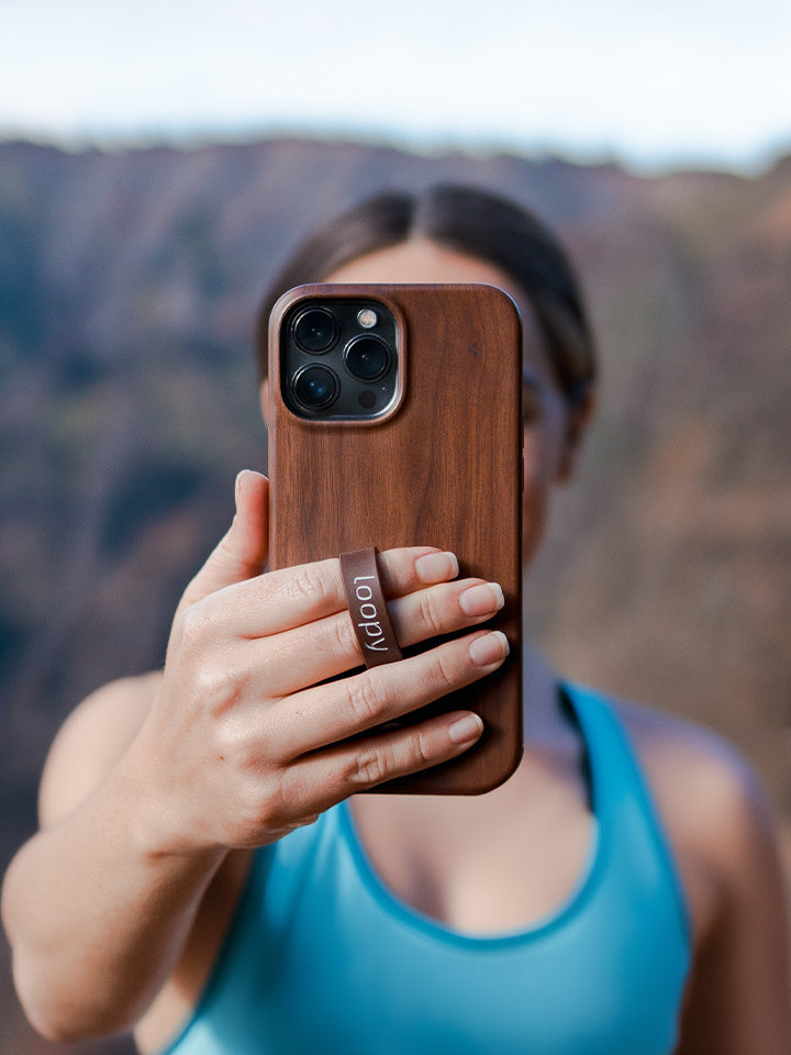 A woman holding a Teakwood Loopy Case. || feature-media