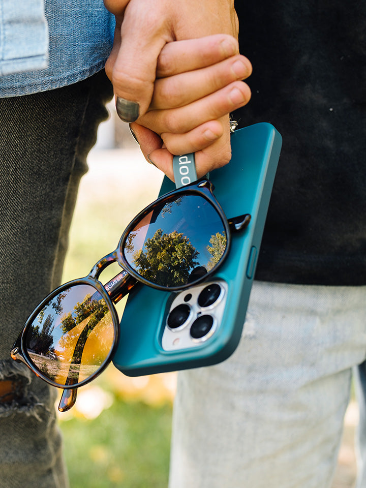 A woman holding a Teal Loopy Case.|| feature-media