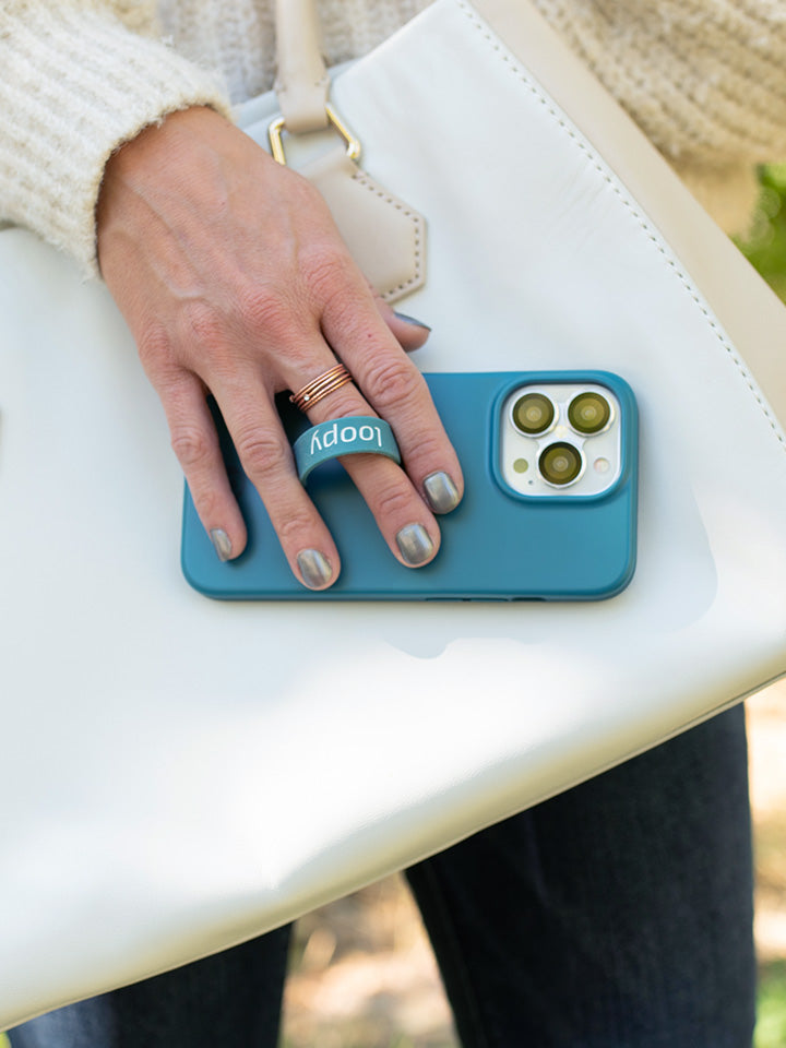 A woman holding a Teal Loopy Case.|| feature-media